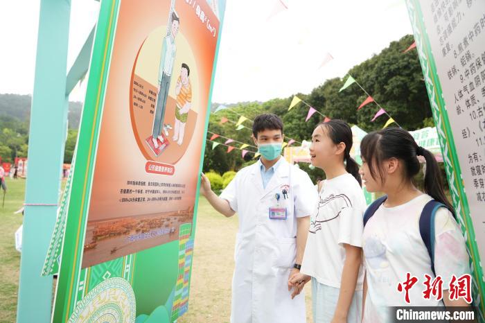 图为广西医护人员向民众介绍公民健康素养知识。　广西壮族自治区卫生健康委员会供图