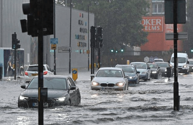 英国伦敦大雨滂沱市区街道积水 车辆受困洪水中