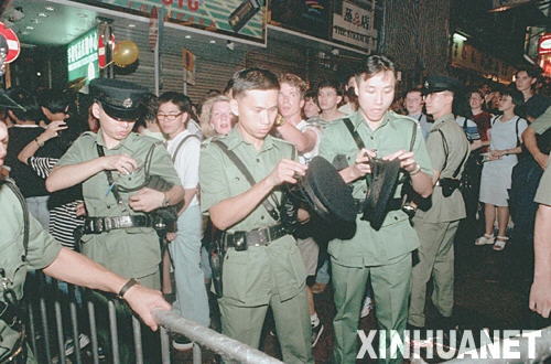 1997年6月30日午夜，香港警察更换带有紫荆花图案的新警徽。