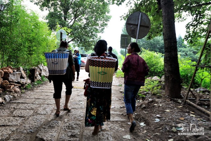 当地的少数民族妇女，背着自编的箩筐，里面装着自家地里种植的瓜果，去古城里贩卖。