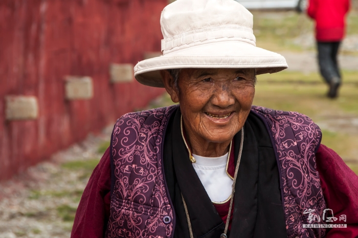旁边，一位年纪更大的藏族大妈，手里拄着拐杖，围着白塔，艰难地转了一圈又一圈。