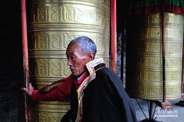 川西新都桥至塔公草原间不知名的寺庙前，一位藏族老伯转动了门前的转经筒。