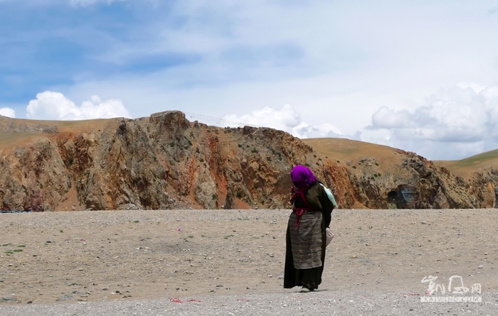西藏那曲地区纳木错旁，一位藏区妇女从扎西半岛走过。