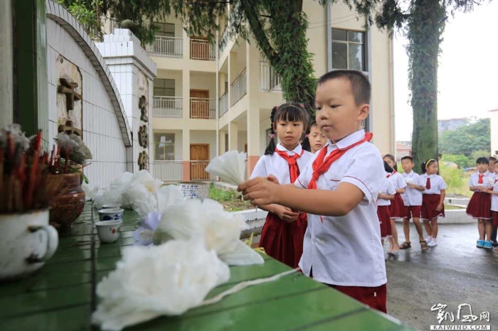 图3：9月30日，在广西柳州市融安县长安镇一处烈士纪念碑前，小学生在烈士纪念碑敬献手工制作的白花。（谭凯兴摄）副本