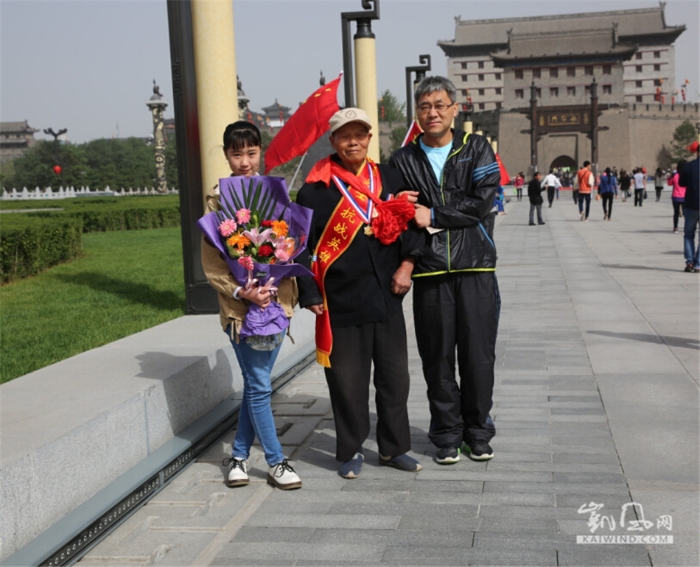 　　陕西抗战老兵在志愿服务队的帮助下来到南门外广场与国旗合影