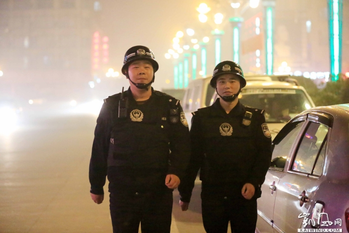 图10：2月18日夜，值班民警谢巍（左）和同事在广西柳州市融安县广场南路巡逻。（谭凯兴摄）副本