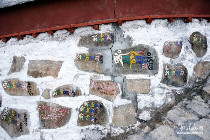 围墙的石块上，刻满了彩色的藏经文，既是一种装饰，同时也使人感受到佛教气氛的无所不在。