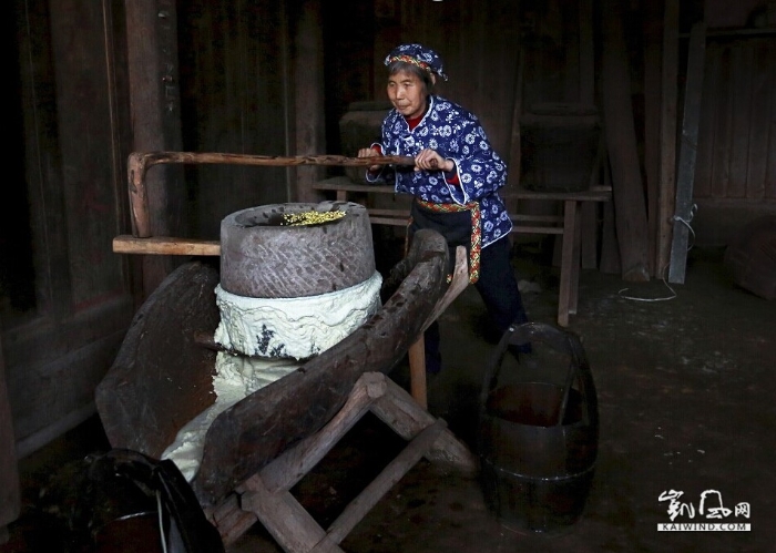 磨浆—将泡好的黄豆放入石磨中碾磨成白白的豆渣浆流入木桶中