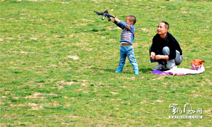 2014年4月7日，西安市南湖公园，父子俩在草地上玩耍