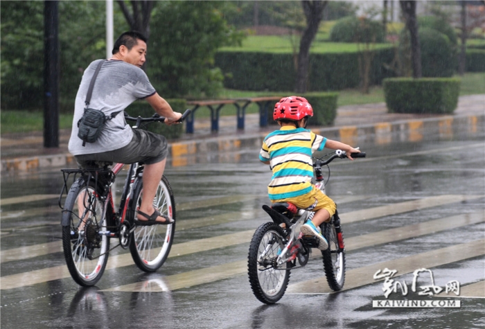 2014年8月30日拍摄，西安市长安区郭杜，父子俩骑车行走在大路上。