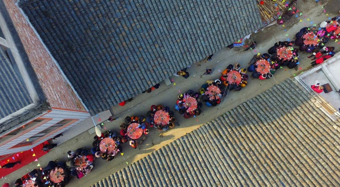 图2：2月11日，广西柳州市融安县板榄镇社区，居民正围坐在一起吃“长街宴”。（谭凯兴 摄）