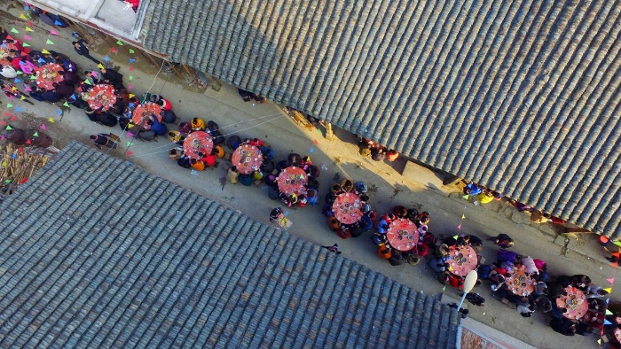 图4：2月11日，广西柳州市融安县板榄镇社区，居民正围坐在一起吃“长街宴”。（谭凯兴 摄）
