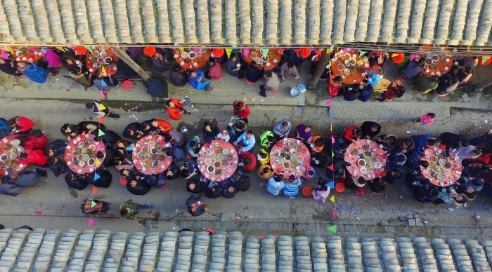 图6：2月11日，广西柳州市融安县板榄镇社区，居民正围坐在一起吃“长街宴”。（谭凯兴 摄）