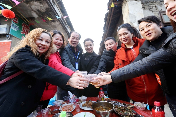 图16：2月11日，广西柳州市融安县板榄镇社区，社区居民互相敬酒共同祝福。（谭凯兴 摄）