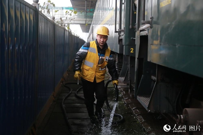 由于经停时间短，上水工们只能不停地穿梭在火车间，每人负责给6到7节车厢加水。