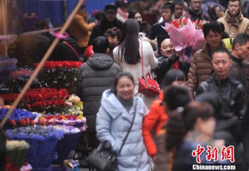 资料图：一男子举着鲜花穿梭在人群中。　陈超 摄