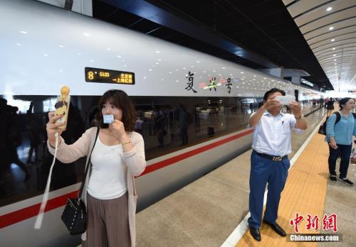 资料图：2017年6月26日，具有完全自主知识产权的中国标准动车组“复兴号”在京沪高铁正式双向首发。图为乘客在北京南站与准备出发的CR400AF“复兴号”列车自拍留念。<a target='_blank' href='http://www.chinanews.com/' _fcksavedurl='http://www.chinanews.com/' _fcksavedurl='http://www.chinanews.com/'></table>中新社</a>记者 侯宇 摄