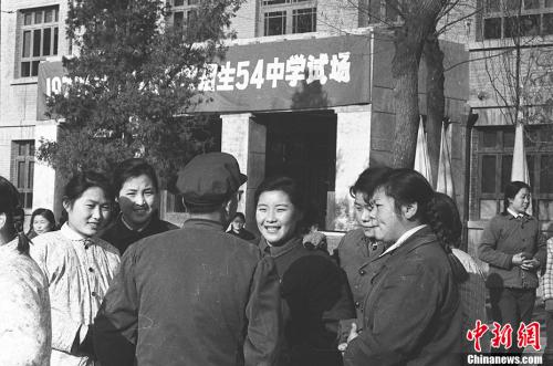 图为1977年12月，北京高考考点的考生们互相交流。 翁乃强 摄 图片来源：视觉中国
