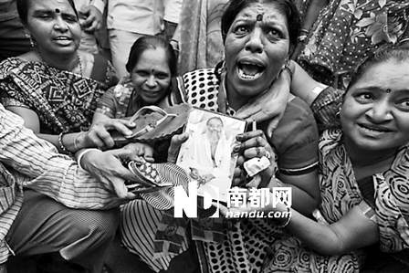 性侵丑闻曝光后，印度妇女用鞋子拍打阿萨拉姆的照片。