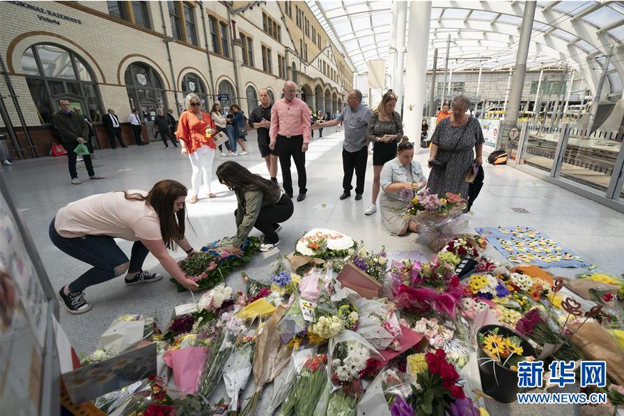 5月22日，在英国曼彻斯特，人们悼念曼彻斯特恐怖袭击中的遇难者。 当日是曼彻斯特恐怖袭击三周年纪念日。2017年5月22日，英国曼彻斯特体育馆发生自杀式爆炸袭击，造成至少22人死亡。 新华社发（乔恩·休珀摄）