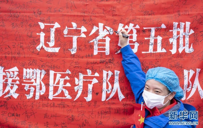 3月29日，在武汉雷神山医院举行的集中撤离仪式上，医护人员签名留念。 当日，武汉雷神山医院举行首批外省医疗队集中撤离仪式，送别即将踏上归途的辽宁、上海、吉林、广东、山西、河北医疗队的1090名医护人员。 新华社记者 才扬 摄