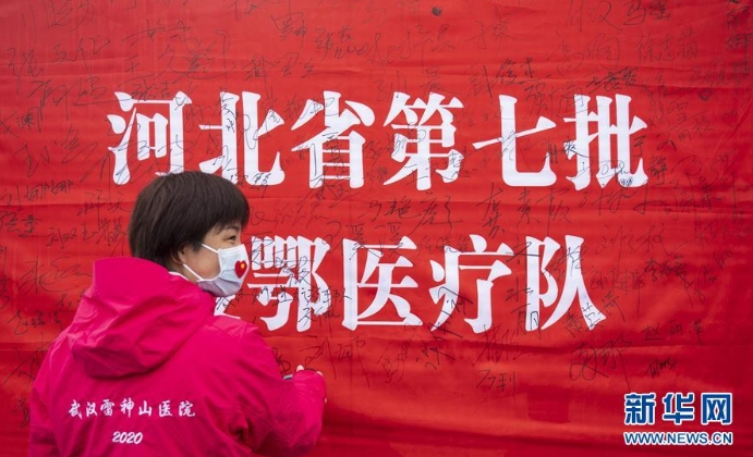 3月29日，在武汉雷神山医院举行的集中撤离仪式上，医护人员签名留念。 当日，武汉雷神山医院举行首批外省医疗队集中撤离仪式，送别即将踏上归途的辽宁、上海、吉林、广东、山西、河北医疗队的1090名医护人员。 新华社记者 才扬 摄