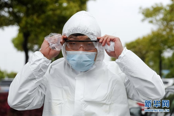 3月31日，尹典在武汉火神山医院外佩戴进入该院工作时所需的护目镜。新华社记者 沈伯韩 摄