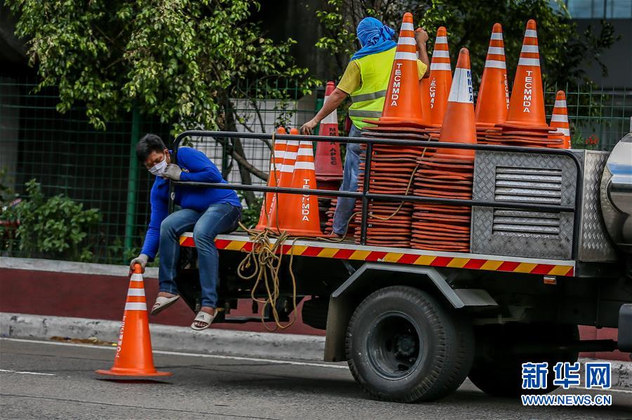 5月31日，在菲律宾首都马尼拉，工作人员用锥筒隔出公交车道，为放松隔离政策后的交通高峰做准备。菲律宾总统杜特尔特28日晚宣布，该国将从6月1日起放松首都马尼拉、第三大城市达沃等多地的严格社区隔离政策，实施一般性社区隔离政策。 新华社发（乌马利摄）