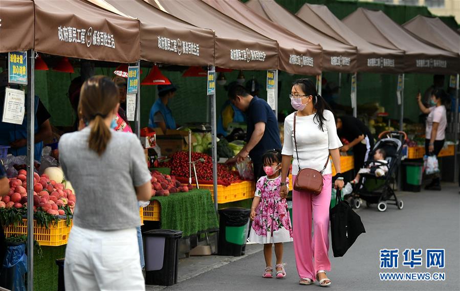 6月2日，在西安市曲江新区金滹沱二路，市民在临时摊区选购食品。 近日，陕西省出台《陕西省促进市场消费积极应对新冠肺炎疫情影响若干措施》，在确保安全的情况下，允许城区临街店铺出店经营，允许在居民居住集中区开辟临时摊点摊区，允许流动商贩在一定时间和区域占道经营。 西安市曲江新区城市管理部门在做好疫情防控工作的前提下，在固定时间、固定区域开辟临时摊点，积极推进“地摊经济”发展。 新华社记者 张博文 摄