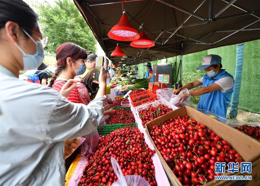 6月2日，在西安市曲江新区金滹沱二路，市民在临时摊区选购食品。 近日，陕西省出台《陕西省促进市场消费积极应对新冠肺炎疫情影响若干措施》，在确保安全的情况下，允许城区临街店铺出店经营，允许在居民居住集中区开辟临时摊点摊区，允许流动商贩在一定时间和区域占道经营。 西安市曲江新区城市管理部门在做好疫情防控工作的前提下，在固定时间、固定区域开辟临时摊点，积极推进“地摊经济”发展。 新华社记者 张博文 摄