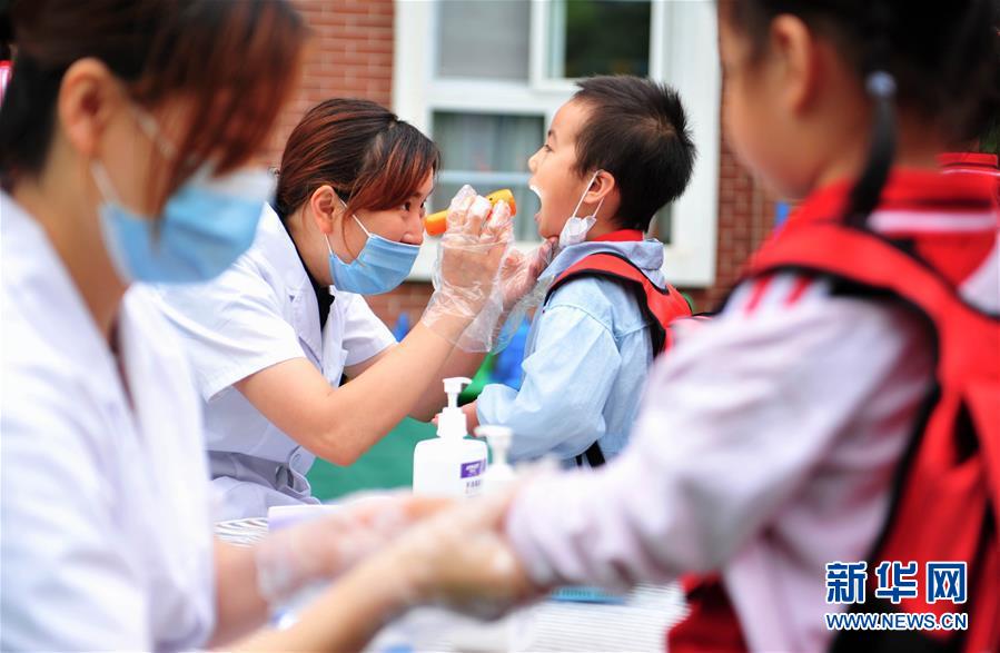 6月2日，成都市龙泉驿区明慧家美育幼儿园恢复开园，小朋友们在接受入园体检。 当日起，四川省成都市幼儿园按照分批分段、错时错峰的原则陆续开园。 新华社发（胥冰洁摄）