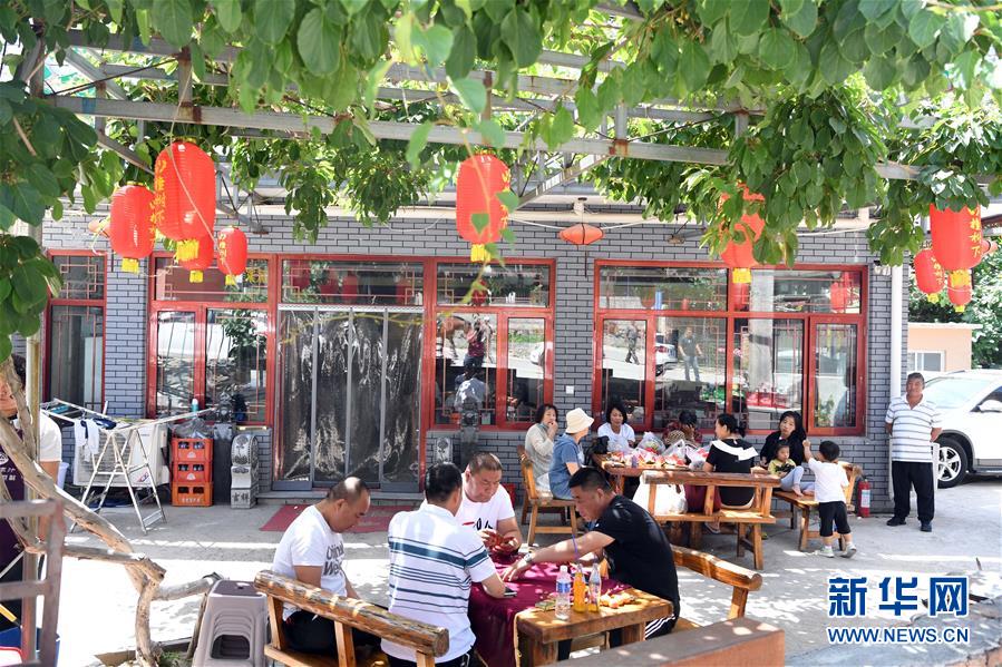6月4日，游客在天津市蓟州区下营镇常州村农家院休闲。 天津市蓟州区下营镇常州村村民以生态文明为理念，集资打造“欧式小镇”，目前当地每年接待游客45万多人，旅游综合收入1.2亿元，其中农家院收入8100多万元，走出了休闲农业与乡村旅游产业结合的乡村振兴之路。 新华社记者 马平 摄