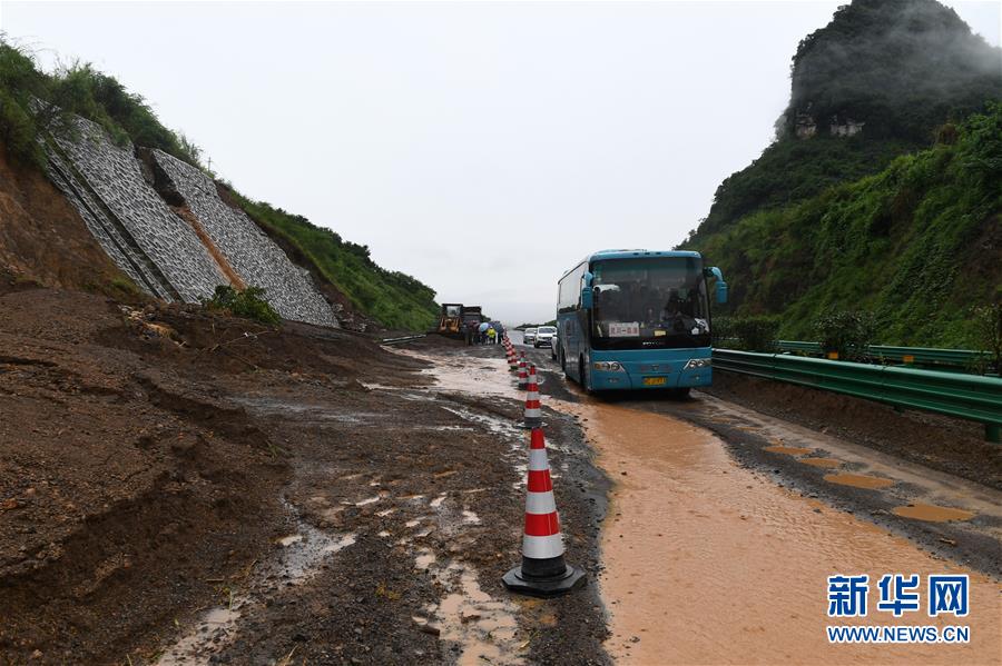 6月7日，在广西鹿寨至阳朔的高速公路上，车辆从一处发生滑坡的路段经过。新华社记者 陆波岸 摄