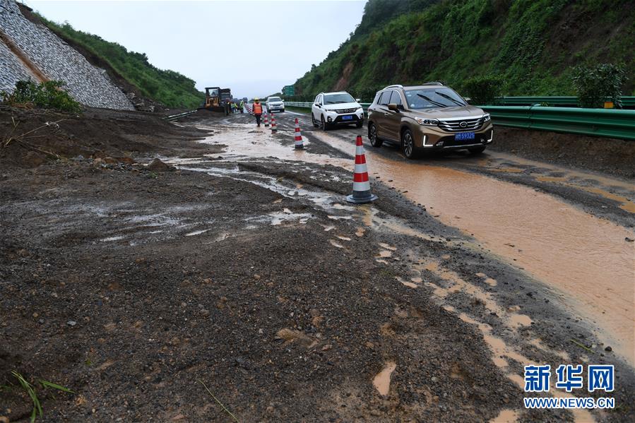 6月7日，在广西鹿寨至阳朔的高速公路上，车辆从一处发生滑坡的路段经过。 新华社记者 陆波岸 摄
