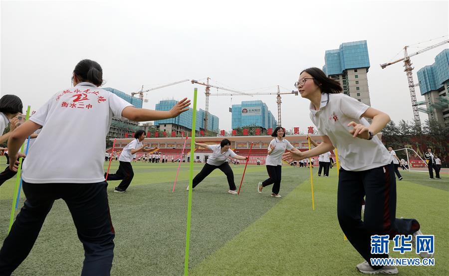 6月9日，河北省衡水市第二中学的高三学生在操场上参加减压趣味游戏。 2020年高考临近，河北省衡水市第二中学组织开展多种形式的集体“减压”活动，帮助高三学生在紧张备考之余释放身心压力，以轻松、乐观、自信的心态迎接高考。 新华社记者 朱旭东 摄