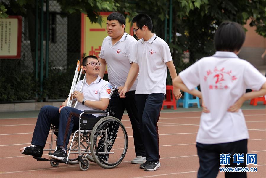 6月9日，河北省衡水市第二中学的高三学生推着一名脚部受伤的同学在操场上聊天散步。 2020年高考临近，河北省衡水市第二中学组织开展多种形式的集体“减压”活动，帮助高三学生在紧张备考之余释放身心压力，以轻松、乐观、自信的心态迎接高考。 新华社记者 朱旭东 摄