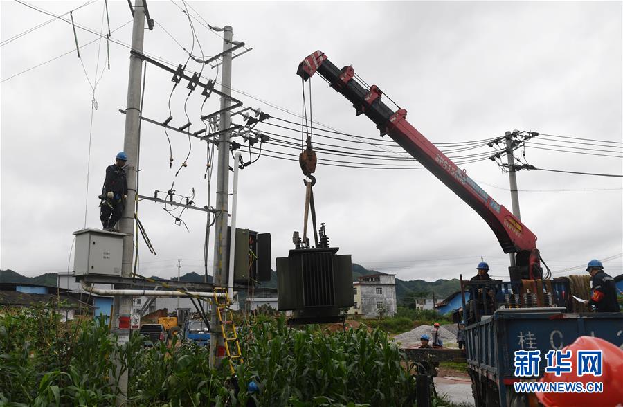 6月9日，在广西桂林市永福县堡里镇，供电部门工作人员更换一台被雷击损坏的变压器。 新华社记者 陆波岸 摄