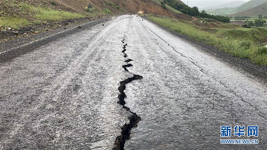 这是6月14日在土耳其东部宾格尔省埃尔马勒村拍摄的开裂的路面。 土耳其东部宾格尔省14日发生5.7级地震，造成数人受伤，目前暂无人员死亡报告。 新华社发
