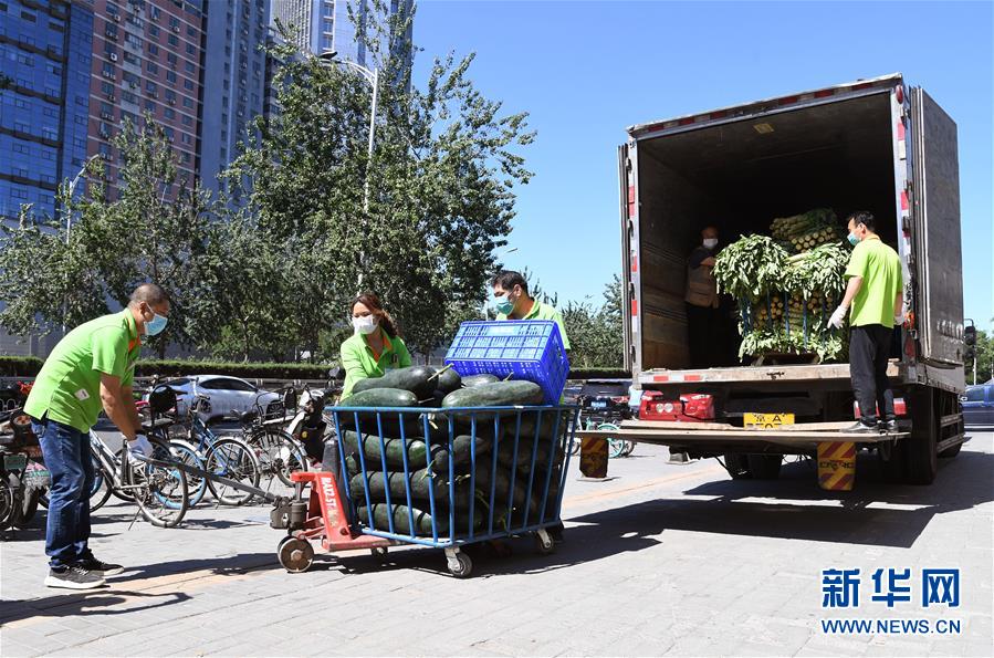 6月14日，在北京市海淀区的超市发双榆树店门口，工作人员在搬运蔬菜。 当日，位于北京市海淀区的超市发双榆树店在做好新冠肺炎疫情防控工作的前提下，保障市场农产品供应。 据了解，超市发双榆树店所有蔬菜、水果均来自于超市发自有配送中心的蔬菜直采产地，配送中心从13日起已经连夜增加京郊、河北、河南等产地的采收量，紧急加车配送，确保蔬菜供应。与此同时，粮、油、米、面等民生必需品供应充足，价格稳定。 新华社记者 任超 摄