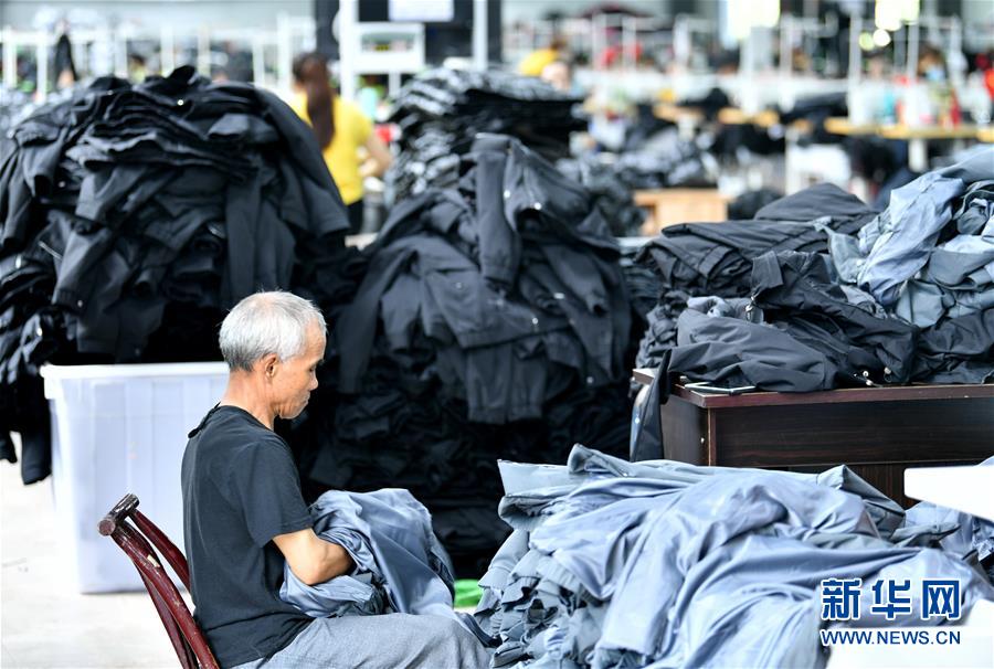 6月16日，在湖北省宣恩县高罗镇一间扶贫工厂的车间里，就业农民在制衣生产线上工作。　　自3月下旬以来，湖北省恩施土家族苗族自治州宣恩县通过优先复工复产、部门跟踪服务、畅通销售渠道等措施，确保当地57家建在易地扶贫搬迁安置点的扶贫工厂、车间正常有序生产销售，为农村低收入群体就业提供保障。 新华社发（宋文 摄）