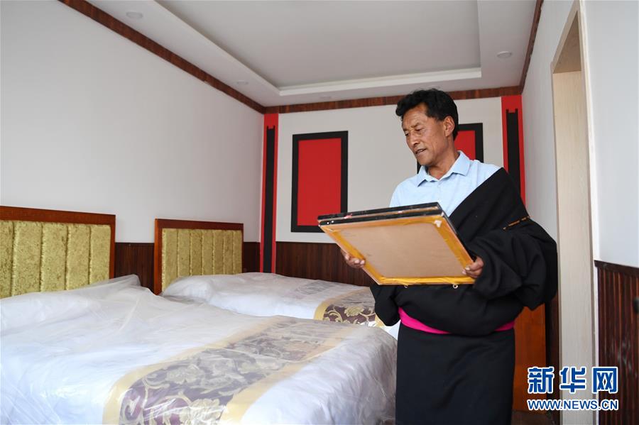 6月20日，甘南藏族自治州碌曲县尕海镇尕秀村党支部书记拉毛加正在收拾自家开办的牧家乐客房。 新华社记者 陈斌 摄