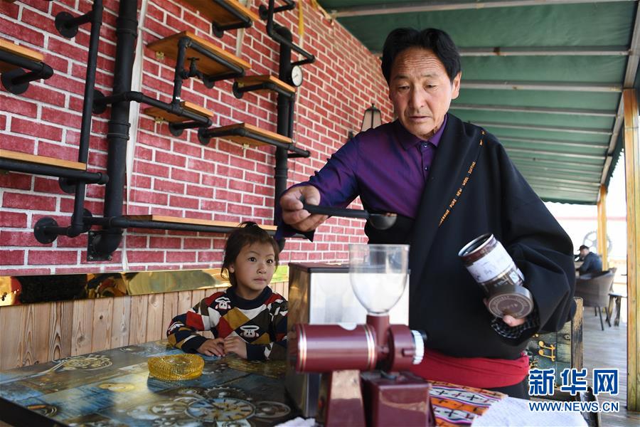6月20日，在甘南藏族自治州碌曲县尕海镇尕秀村，村民格日扎西（右）在自家的牧家乐里调试新买的咖啡机。 新华社记者 陈斌 摄