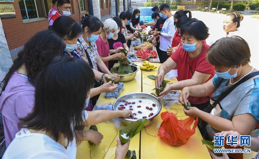 6月22日，志愿者在河北省武强县迎宾社区包粽子。 当日，河北省武强县迎宾社区联合武强县画乡志愿者协会开展“包粽子 迎端午”活动，传承传统文化，增进邻里感情。 新华社记者 李晓果 摄