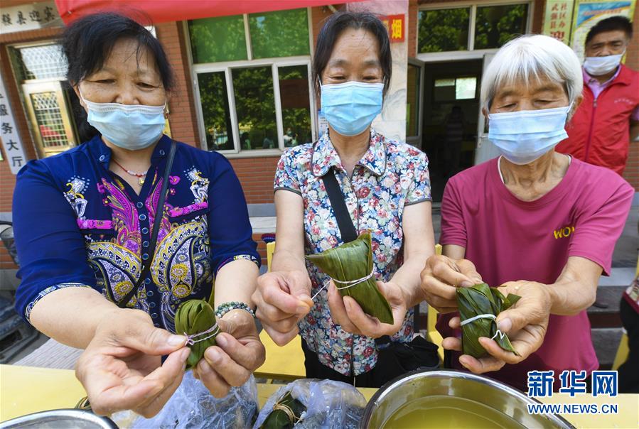 6月22日，志愿者在河北省武强县迎宾社区包粽子。 当日，河北省武强县迎宾社区联合武强县画乡志愿者协会开展“包粽子 迎端午”活动，传承传统文化，增进邻里感情。 新华社记者 李晓果 摄