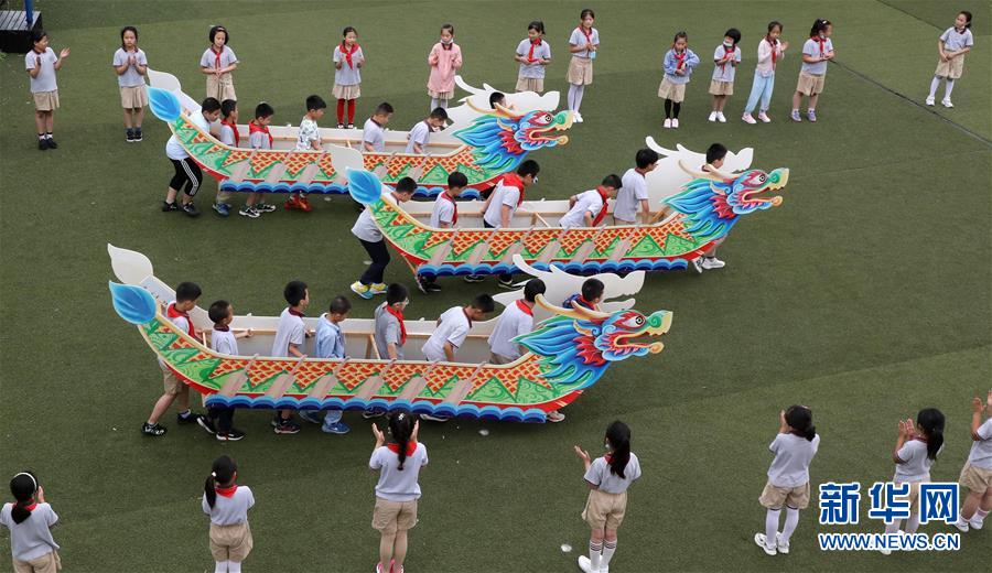 6月22日，江苏省苏州市留园中心小学学生在进行“旱地龙舟”比赛。 端午节将至，各地举办包粽子比赛、制作香囊等民俗活动，感受传统节日的魅力。 新华社发（杭兴微 摄）