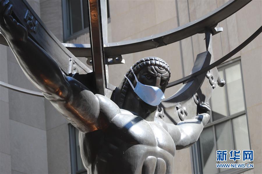 6月22日，在美国纽约洛克菲勒中心，一座雕像被“戴”上口罩。 美国约翰斯·霍普金斯大学22日发布的新冠疫情最新统计数据显示，美国累计死亡病例超过12万例。 新华社记者王迎摄
