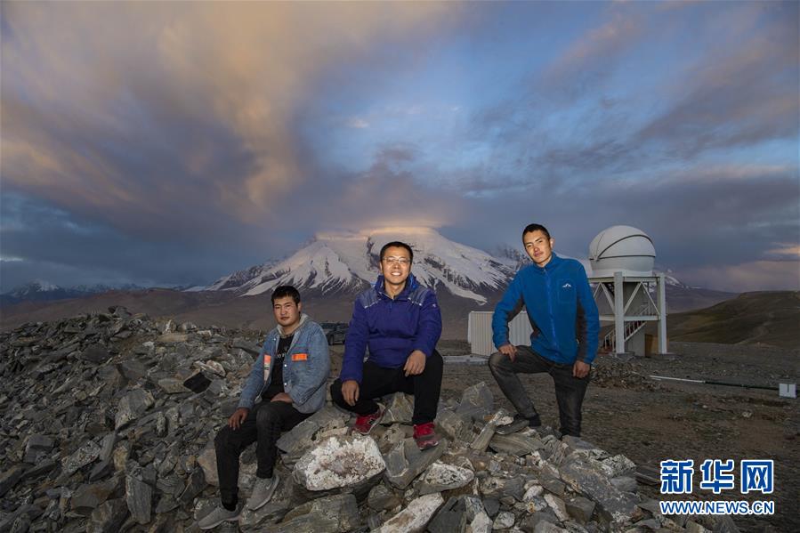 在中国科学院新疆天文台慕士塔格观测站，天文科技工作者冯国杰（中）、助理观测员努尔兰·卡纳皮亚（左）、阿克力·图拉提在慕士塔格峰下合影（6月15日摄）。