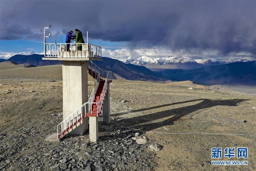 在中国科学院新疆天文台慕士塔格观测站，冯国杰和助理观测员在户外工作（6月15日摄，无人机照片）。  新华社记者 胡虎虎 摄