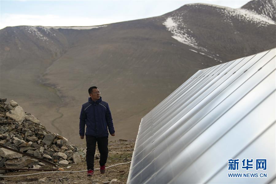 在中国科学院新疆天文台慕士塔格观测站，冯国杰检查太阳能光伏电板的运行情况（6月15日摄）。  新华社记者 胡虎虎 摄