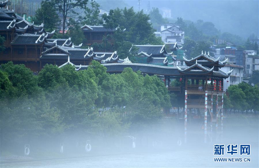 6月23日，一场雨后，湖北省恩施土家族苗族自治州宣恩县贡水河雾气升腾，河畔亭台楼阁若隐若现，宛若仙境。 新华社发（宋文 摄）